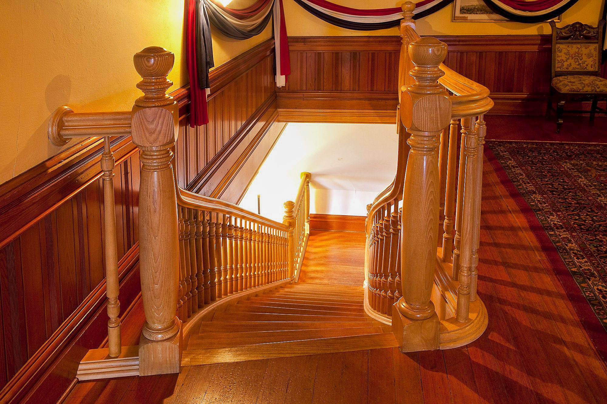 Restored grand staircase at Craigdarroch Castle — heritage restoration by C&W Campbell